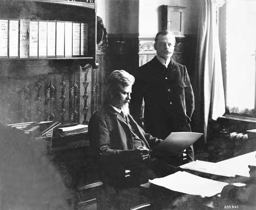 Wilhelm Maybach, der „König der Konstrukteure“, an seinem Schreibtisch. Neben ihm Adolf Daimler, einer der Söhne von Gottlieb Daimler. Foto: Daimler AG Archive