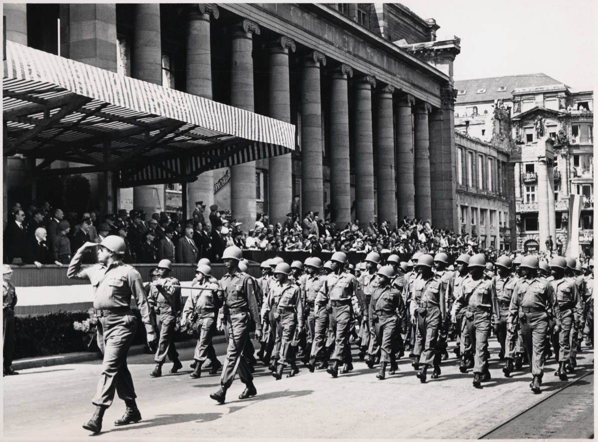 Am 7. Juli 1945 beginnen die französischen Besatzungstruppen Stuttgart zu räumen. Zwei Jahre später, am 4. Juli 1947, findet auf dem Stuttgarter Schlossplatz aus Anlass des amerikanischen Unabhängigkeitstages eine große Truppenparade statt. Die Tribüne für die Ehrengäste steht vor dem zerstörten Königsbau.